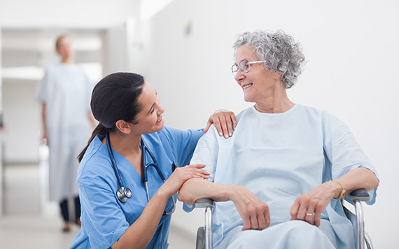Elderly patient looking at a nurse in hospital ward